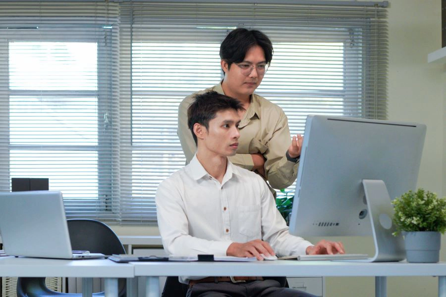 Two researchers talking behind a computer